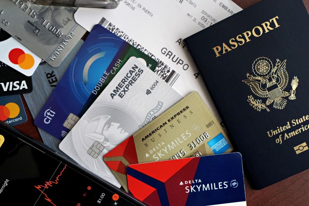 A collection of travel essentials including a passport, credit cards, and a boarding pass