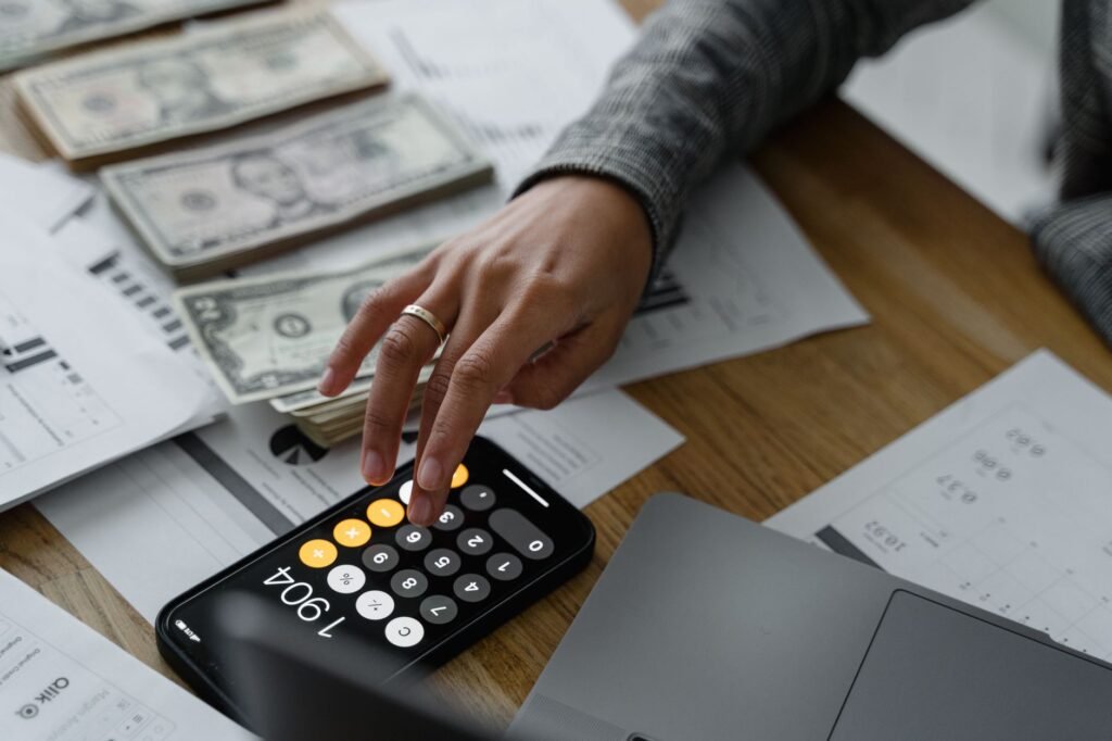 A person calculating their savings for retirement using a calculator