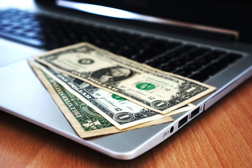 Close-up of US dollar bills placed on a laptop symbolizing digital finance and economy