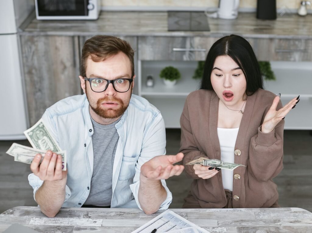 Interracial couple shocked while handling cash in a modern kitchen