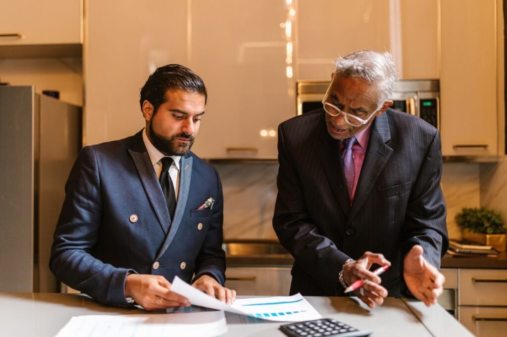 Two businessmen engaged in a focused discussion over financial documents in a modern office setting