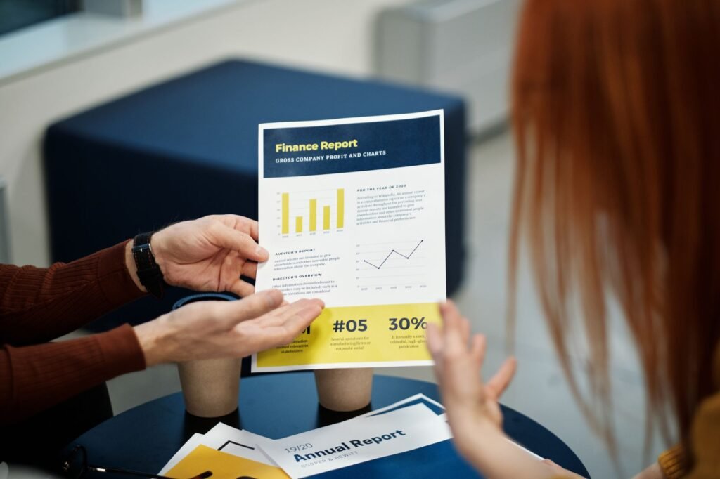 Two individuals analyzing a finance report chart at a business meeting in an office setting