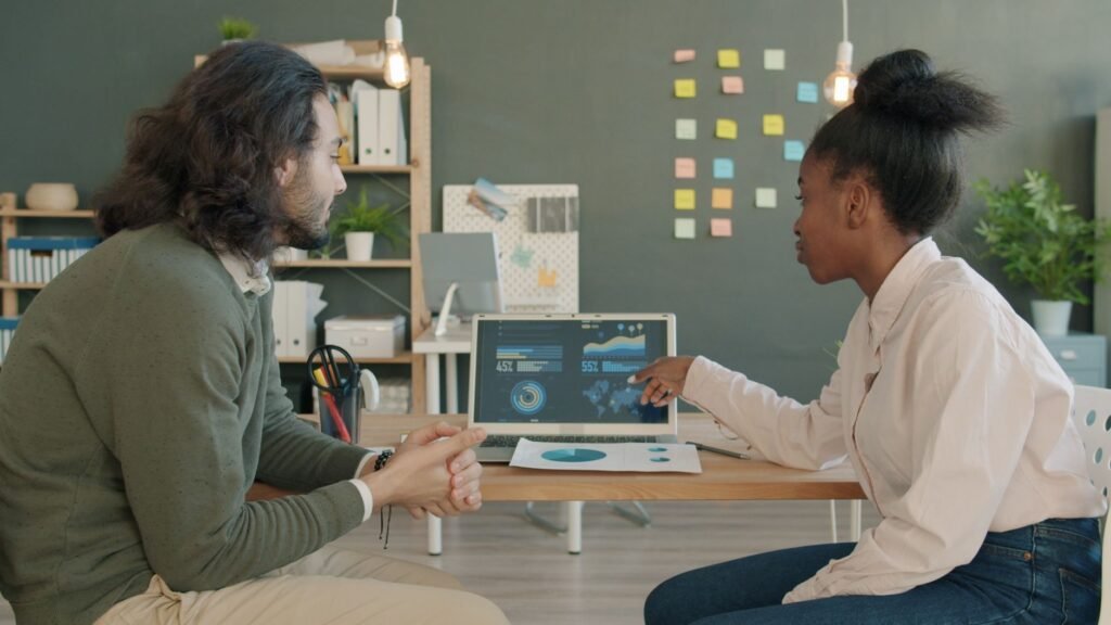 Two professionals collaborating on data analysis in a modern office