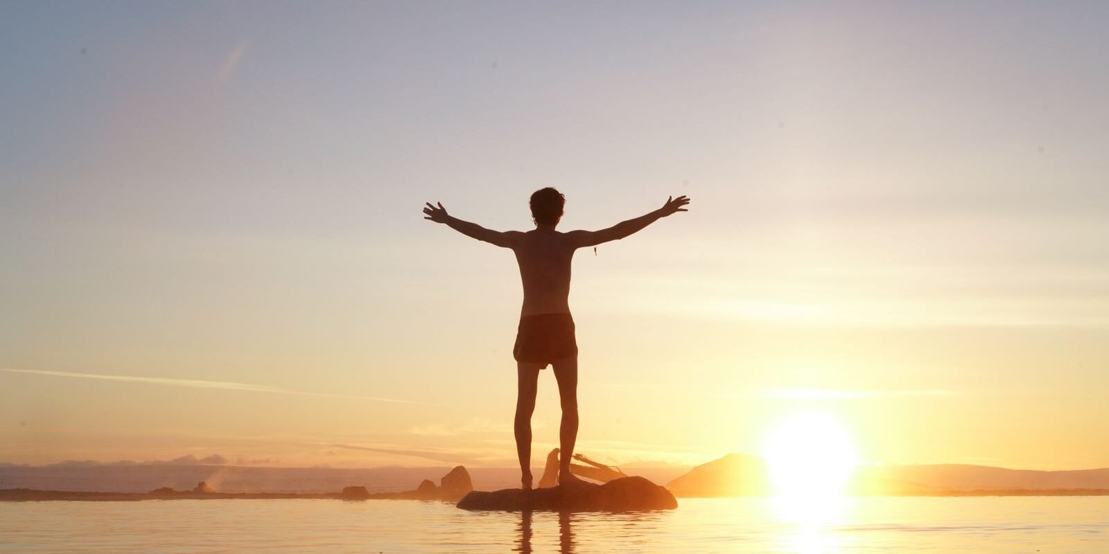 Person celebrating freedom at sunrise