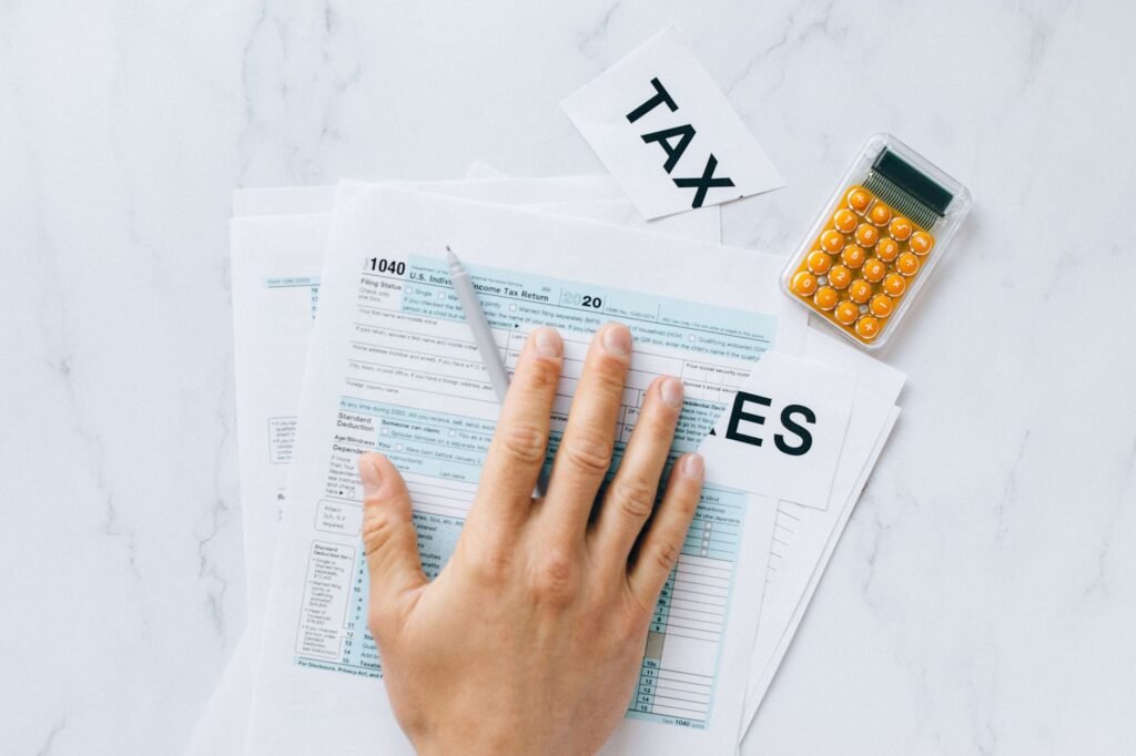 Close-up of a hand on tax form 1040 with a calculator on a desk