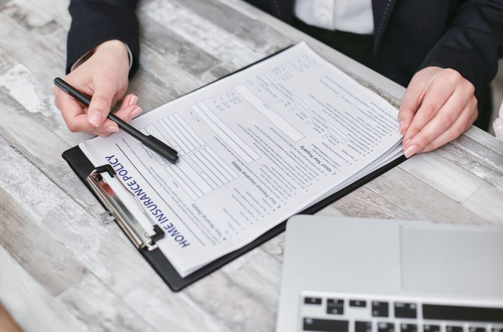 Close-up of hands reviewing a home insurance policy, emphasizing professionalism and finance