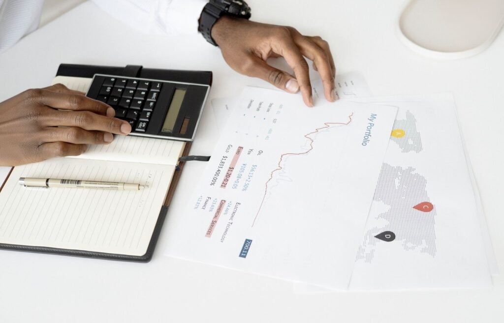 Overhead view of a person analyzing financial documents using a calculator for investment planning