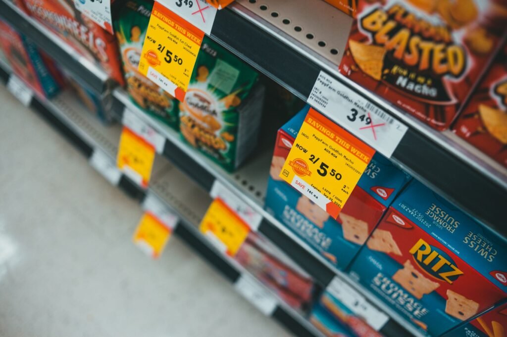 Supermarket aisle featuring discounted snacks with visible sale tags and prices