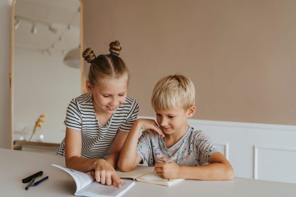Two kids studying together at home, focusing on a book in a calm, indoor setting